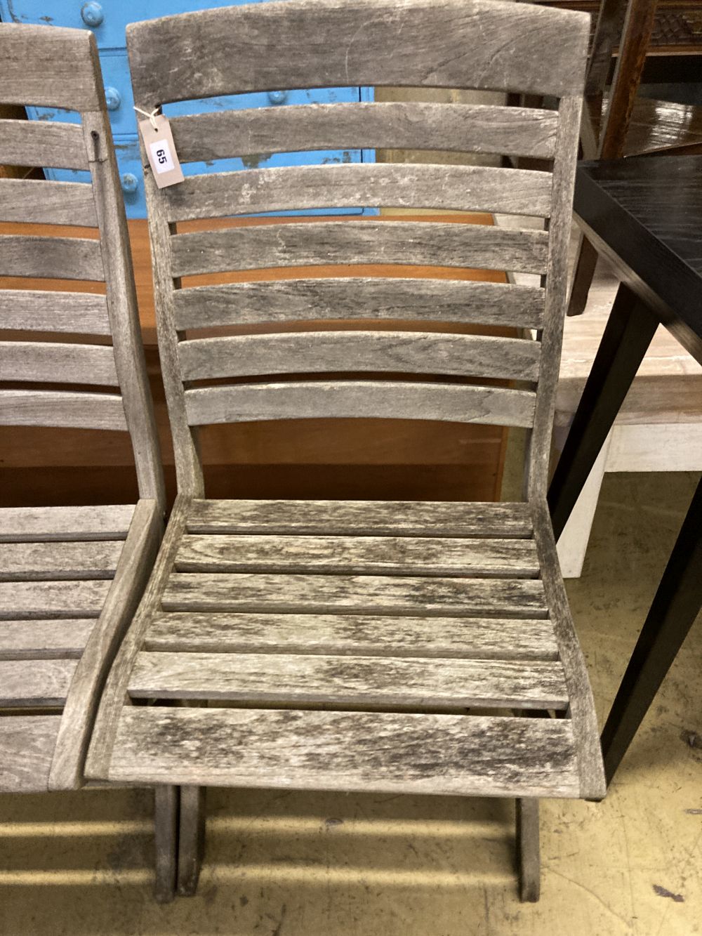 A set of four weathered teak folding garden chairs